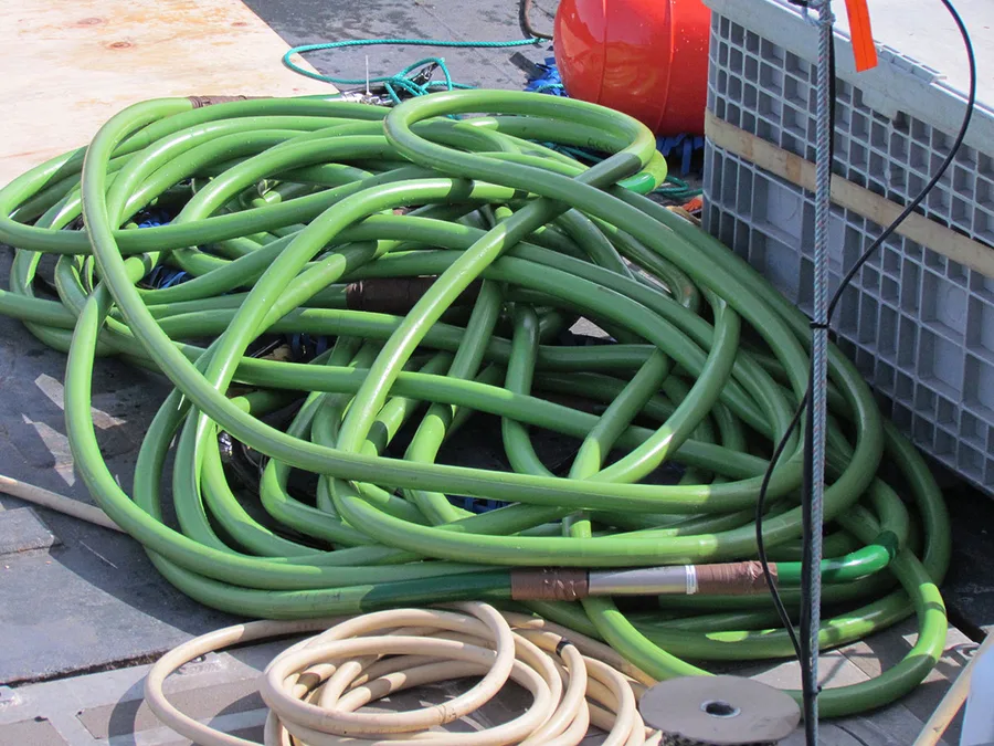 Kabel streamer seismik multichannel berwarna hijau tergulung di dek kapal riset